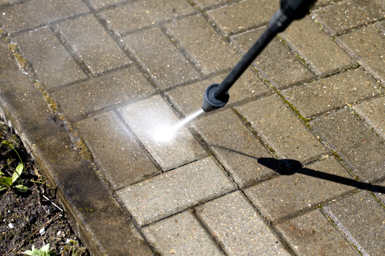 Commercial pressure washing a concrete surface with a high-pressure water jet