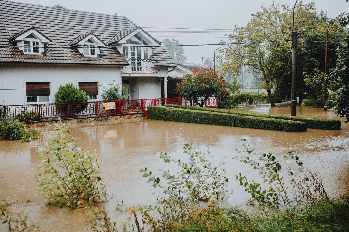 A suburban property surrounded by floodwaters after heavy rain, illustrating water damage risk