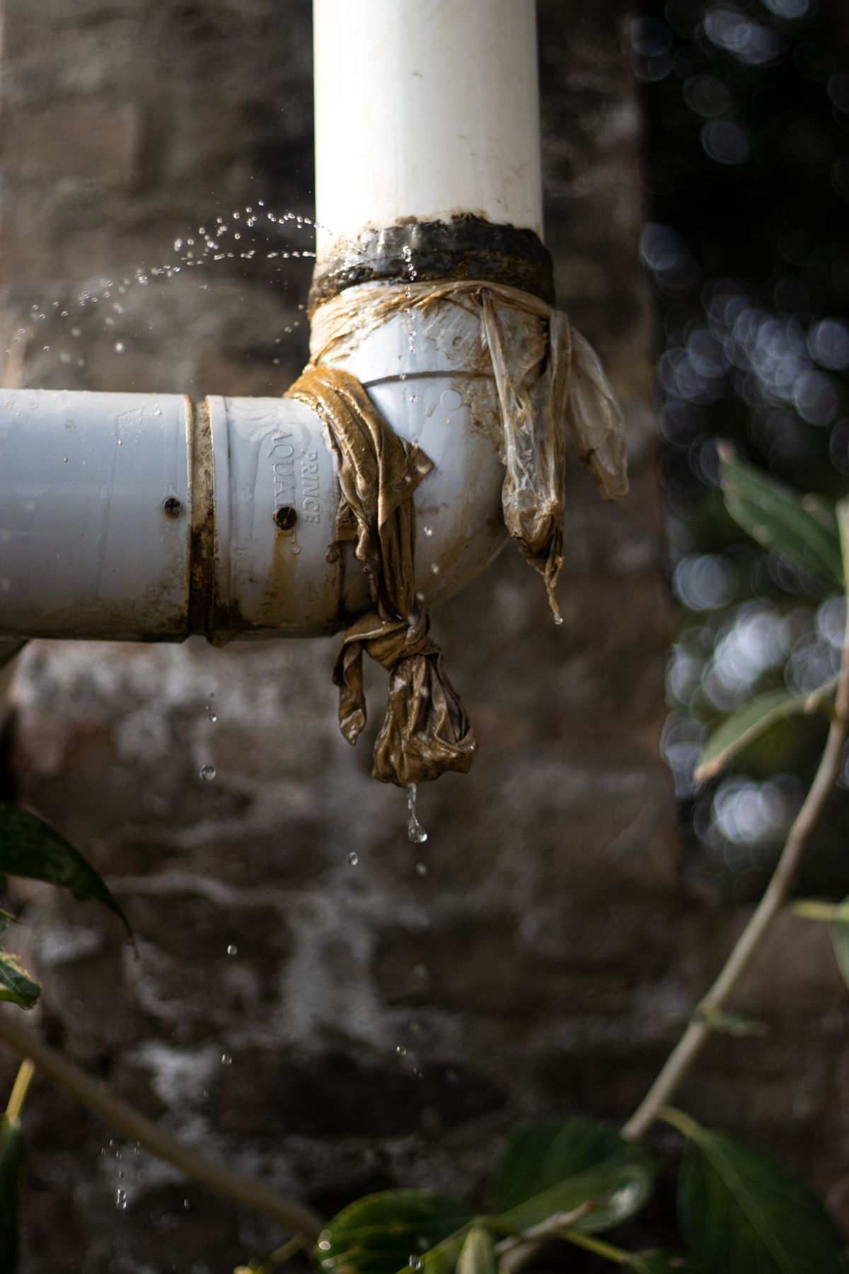 Close-up of a leaking pipe with water dripping, a common source of water damage