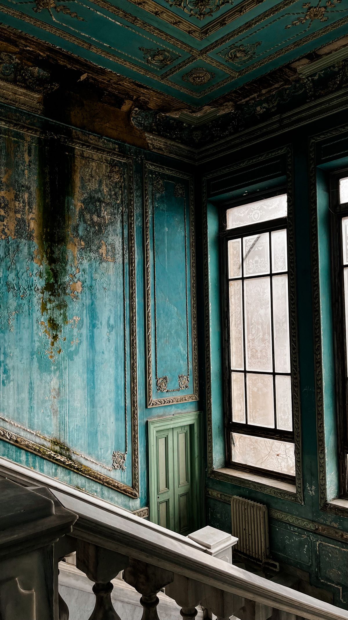 A wall with peeling paint and damp damage indicating hidden moisture and potential mould